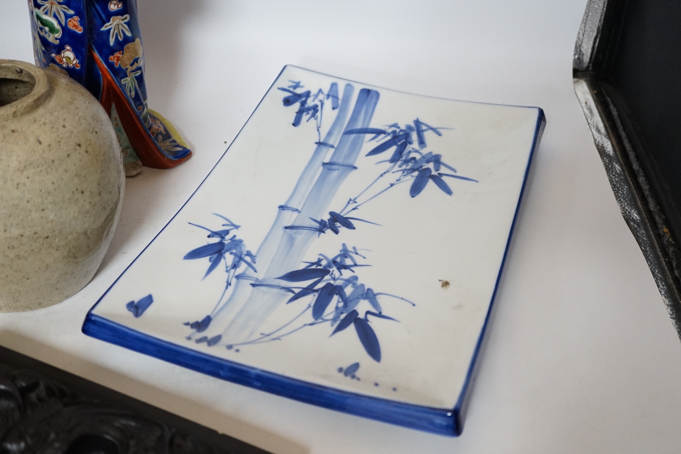 A 20th century Chinese porcelain figure, a stoneware jar, a ‘dragon’ inkstone and a Japanese dish, figure 37cm
